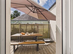 Eine Terrasse im Freien mit einem Holztisch, einer Bank und einer Picknickausstattung.