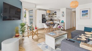 Eine moderne Wohnung mit Wohnzimmer, Essbereich, Küche und einem Balkon.