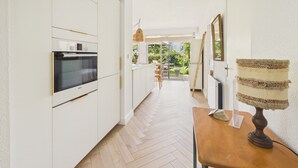 Eine moderne Küche mit weißen Schränken, einem Bosch-Ofen und Holzboden.