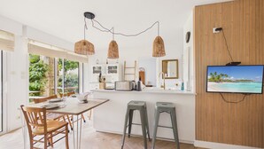 Eine moderne Küche mit einer großen Kochinsel, Holzböden und einem an der Wand montierten Fernseher.