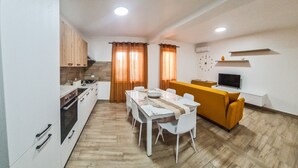 A compact living space with a kitchen, dining area, and a sofa. - Dream House - Phoenix (Marina di Palma)