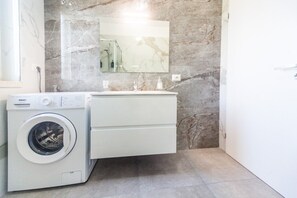 A compact bathroom with a washing machine, a sink, and a mirror. - Dream House - Albatross (Marina di Palma)