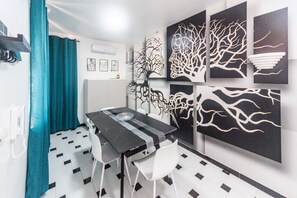 A modern room with a black and white checkered floor, a dining table with chairs, and abstract wall art. - Dream House - Albatross (Marina di Palma)