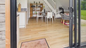 Una cocina moderna con comedor, una escalera y vistas al exterior.