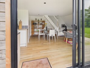 Une cuisine moderne avec un coin repas, un escalier et une vue sur lâextĂ©rieur.
