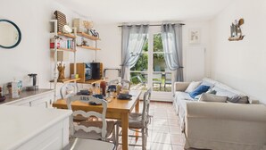 Una sala de estar acogedora con comedor, un sofá y una estantería.