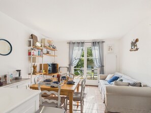 Ein gemütliches Wohnzimmer mit Essbereich, einer Couch und einem Bücherregal.