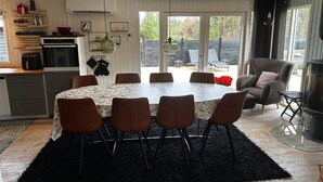 Una cocina moderna con comedor, que incluye una mesa redonda con sillas, una alfombra negra y una chimenea.