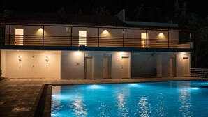 Un edificio de dos pisos con una piscina delantera.