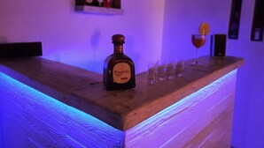 A bar area with a bottle of Don Julio tequila, glasses, and a bottle of wine on a wooden counter. - Cosy Villa Walking Distance to a Mykonian Beach (Mykonos)