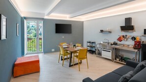 A modern living space with a dining area, kitchen, and a large window. - Apartment 'Parmenide Family' with Wi-Fi and Air Conditioning (Ascea)