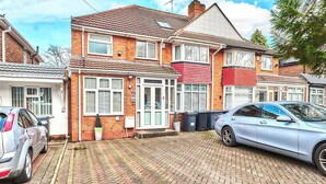 A residential area with houses, a paved driveway, and parked cars. - House Sleeps 8 - Free Parking & Wifi (Birmingham)