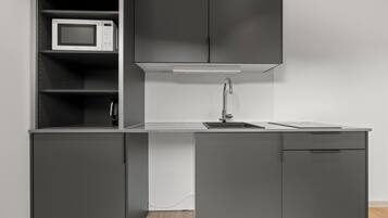 A modern kitchen with a microwave, a sink, and cabinets.
