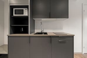 A modern kitchen with a built-in microwave, a sink, and a dishwasher.