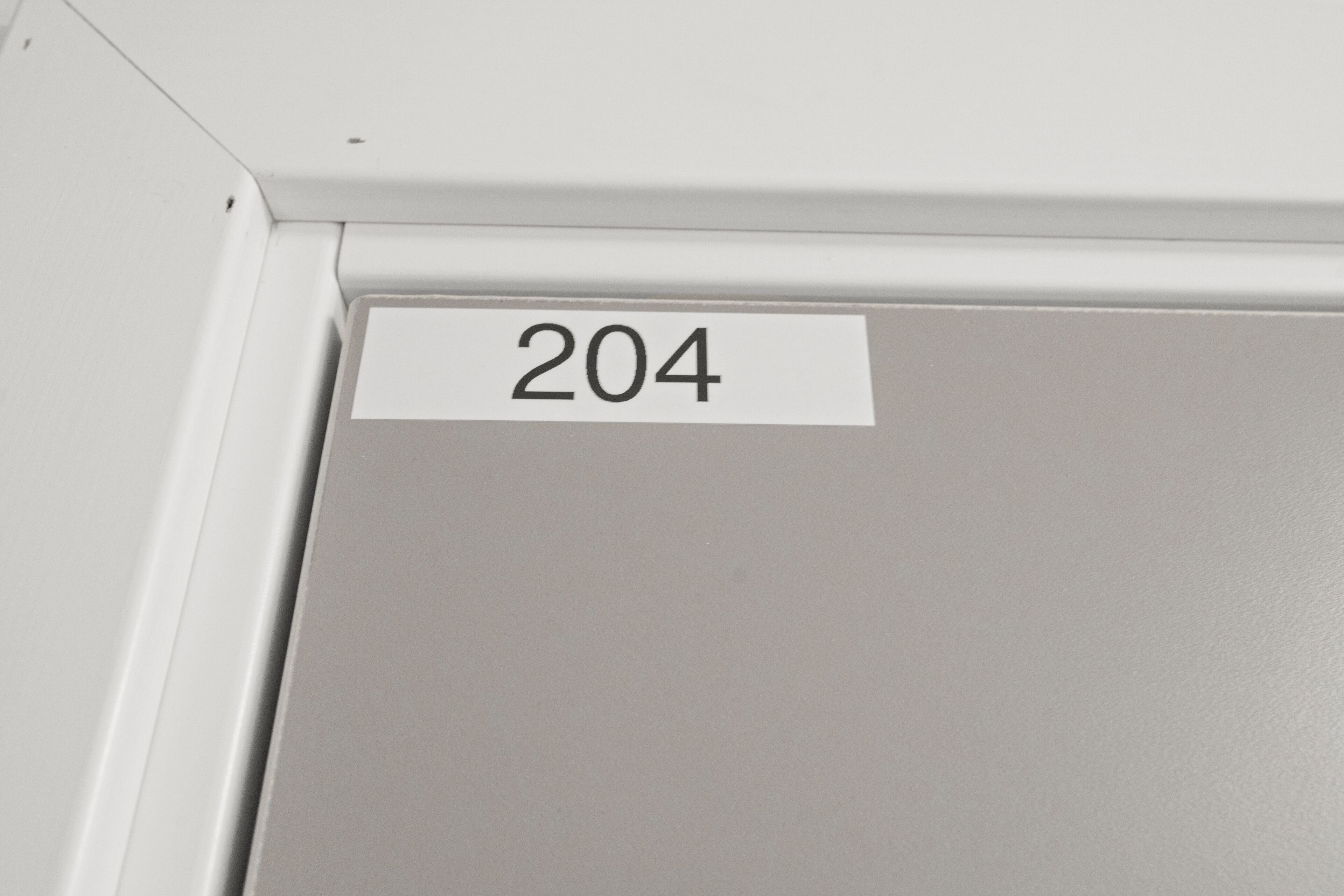 A door with a white label displaying the number 204.