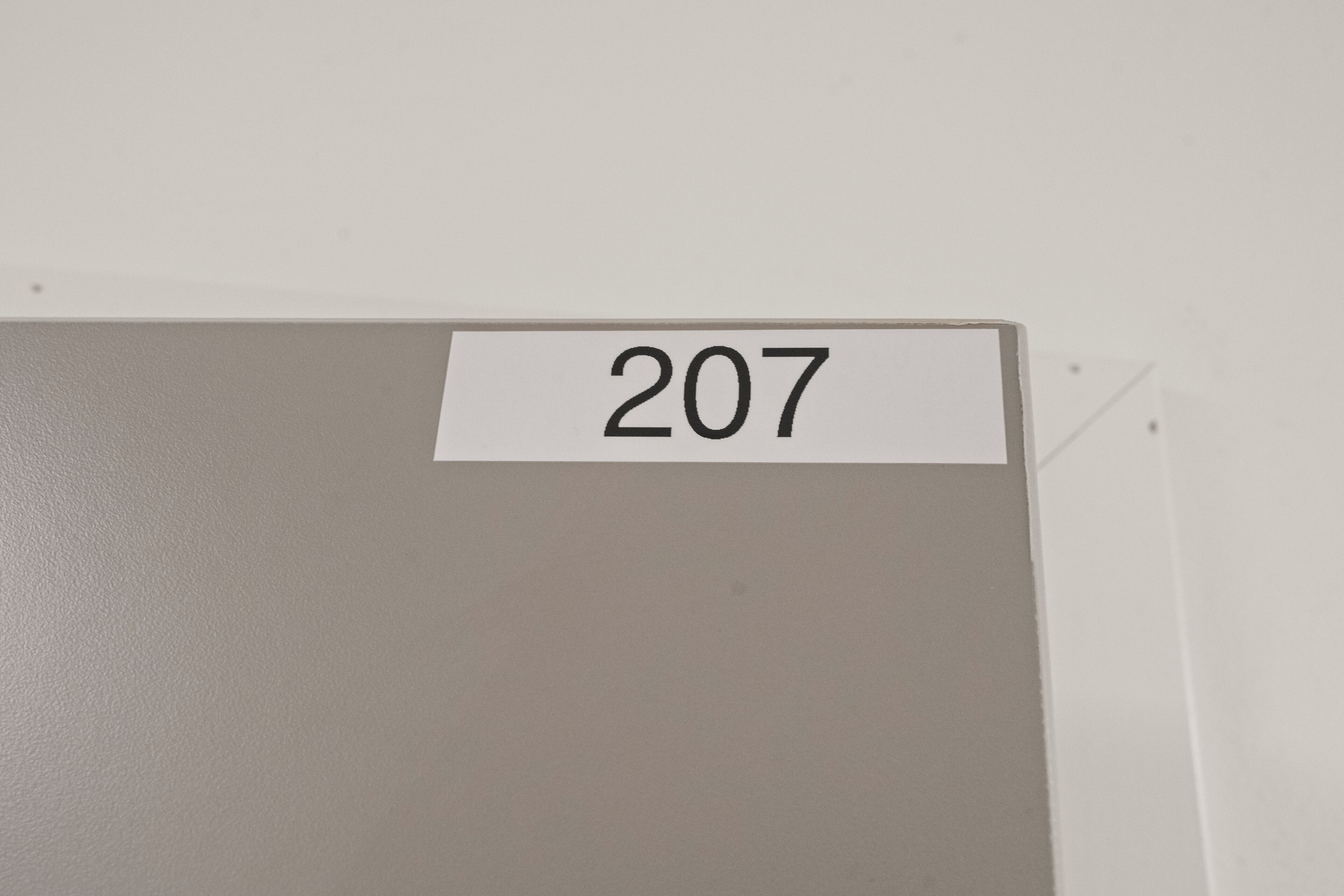 Un mur sur lequel est apposée une étiquette portant le numéro « 207 ».