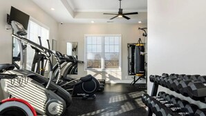 Un gimnasio con cintas de correr, pesas y un saco de boxeo.