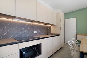 Eine moderne Küche mit integriertem Mikrowellenherd, Spüle und Arbeitsplatte.