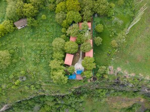 Une vue aérienne d’une propriété comprenant plusieurs bâtiments, le tout entouré d’une végétation luxuriante.