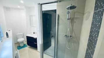 Chuveiro, secador de cabelo, toalhas de banho, papel higiênico