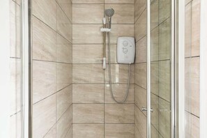 A shower with a handheld showerhead and a wall-mounted control panel. - Birmingham Estate | Detached Home for Togetherness (Birmingham)