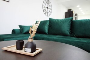 A modern living room with a dark brown round table, a black vase with dried plants, and a black mug on a wooden tray. - Cardiff Bloc | The Ultimate Group Stay for 10 (Rumney)