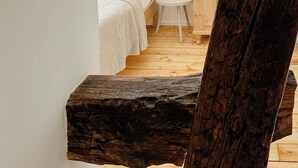Ein Schlafzimmer mit einem Bett, einem kleinen weißen Tisch und einem Holzschrank.