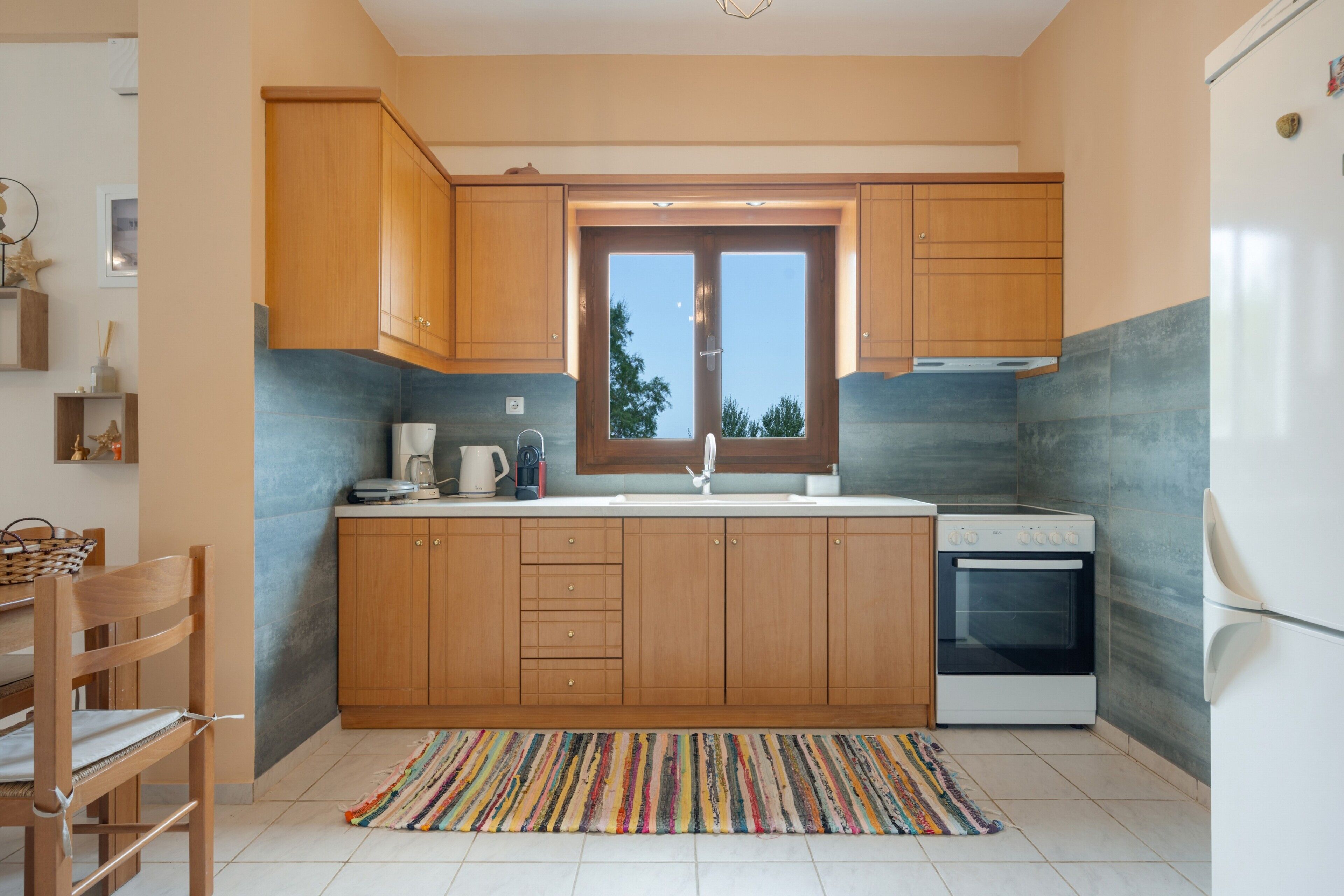 A kitchen with wooden cabinets, a built-in oven, and a window.