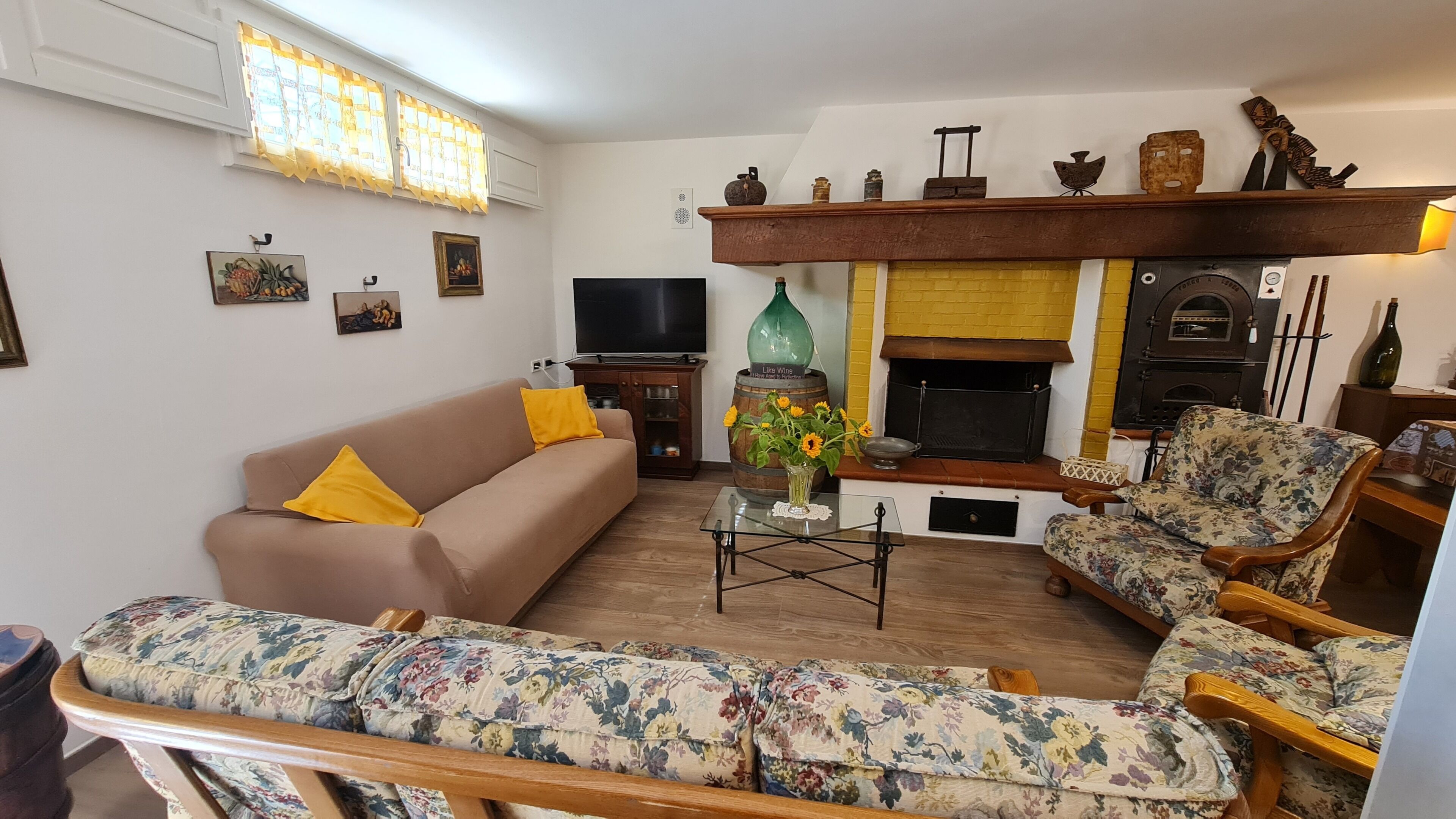 A living room with a sofa, armchair, TV, fireplace, and decorative items.