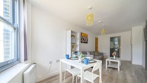 Un appartement moderne comprenant un coin repas, une cuisine et un espace de vie.