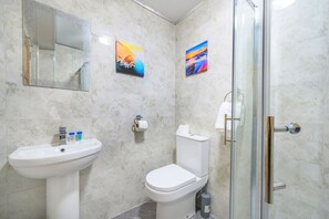 A bathroom with a sink, toilet, and glass shower enclosure. - Soothing and Welcoming Stay in West Yorkshire (West Yorkshire)