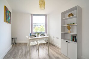 A room with a dining table, two chairs, a bookshelf, and a window with a view. - Soothing and Welcoming Stay in West Yorkshire (West Yorkshire)
