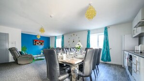 Un espace repas moderne comprenant une grande table, des chaises et un fauteuil de massage.
