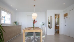 Cozinha moderna com área de jantar, uma janela grande e vista da cidade.