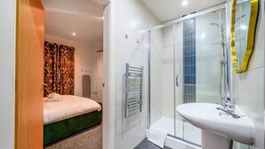 Ein modernes Badezimmer mit Dusche, Waschbecken und Handtuchhalter.
