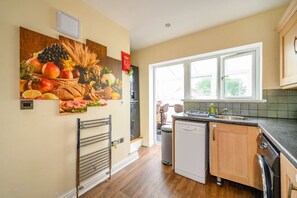 A kitchen with a dishwasher, a sink, and a window. - H17A Cosy & Welcoming home (West Yorkshire)