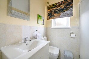Ein Badezimmer mit Badewanne, Toilette und Fenster.