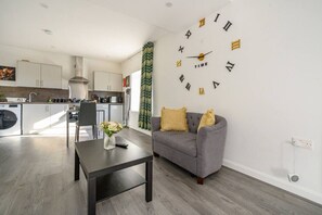 A modern living room with a grey sofa, a coffee table, and a wall clock. - *11F2* Captivating & luxurious Stay (West Yorkshire)