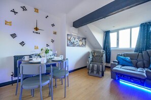 A modern living room with a dining area, a massage chair, and a sofa with blue lighting. - 14GH* For your relaxed and Cosy stay with Free (West Yorkshire)