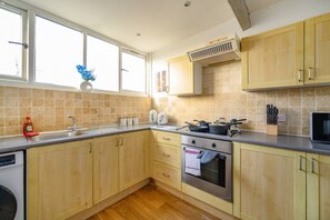 A kitchen with wooden cabinets, a stainless steel oven, a microwave, and a window with a view. - 14GH* For your relaxed and Cosy stay with Free (West Yorkshire)