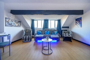 A living room with a sofa, two massage chairs, a small round table, and artwork on the walls. - 14GH* For your relaxed and Cosy stay with Free (West Yorkshire)