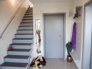 A staircase leading to a door, a potted plant, and a stuffed toy on the floor. - Landglück – Vacation home with a terrace, garden, and space for up to 9 guests (Oesterdeichstrich)