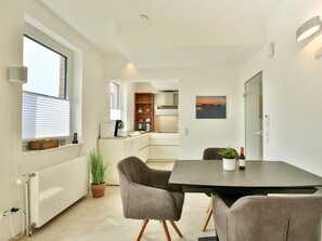 Eine moderne Küche mit Essbereich, Blick auf die Stadt und einer gemütlichen Sitzecke.
