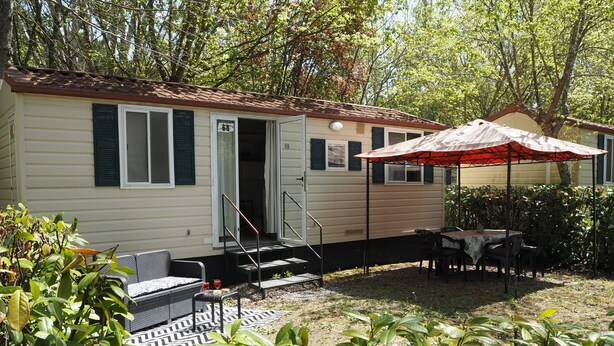 A mobile home with a patio area, outdoor seating, and a covered table. - 5-person Mobile Home Near Chianti (Bucine)