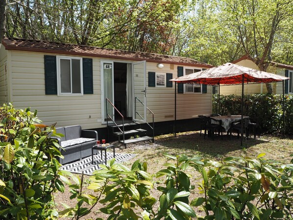 A mobile home with a patio area, outdoor seating, and a covered table. - 5-person Mobile Home Near Chianti (Bucine)
