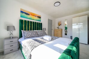 A bedroom with a bed, a nightstand, a dresser, a wardrobe, and a painting on the wall. - -VL- Stylish & Relaxed Stay/Free Parking/Free WiFi (Hawksworth)