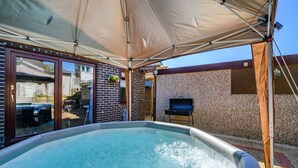 An outdoor swimming pool with a canopy, a barbecue grill, and a brick wall. - Stylish Home with Hot Tub in Hawksworth (Hawksworth)