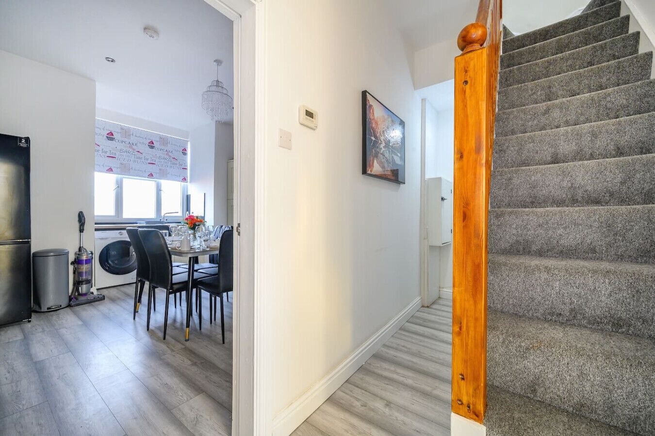 Een trap die leidt naar een plateau, met een eethoek op de achtergrond.