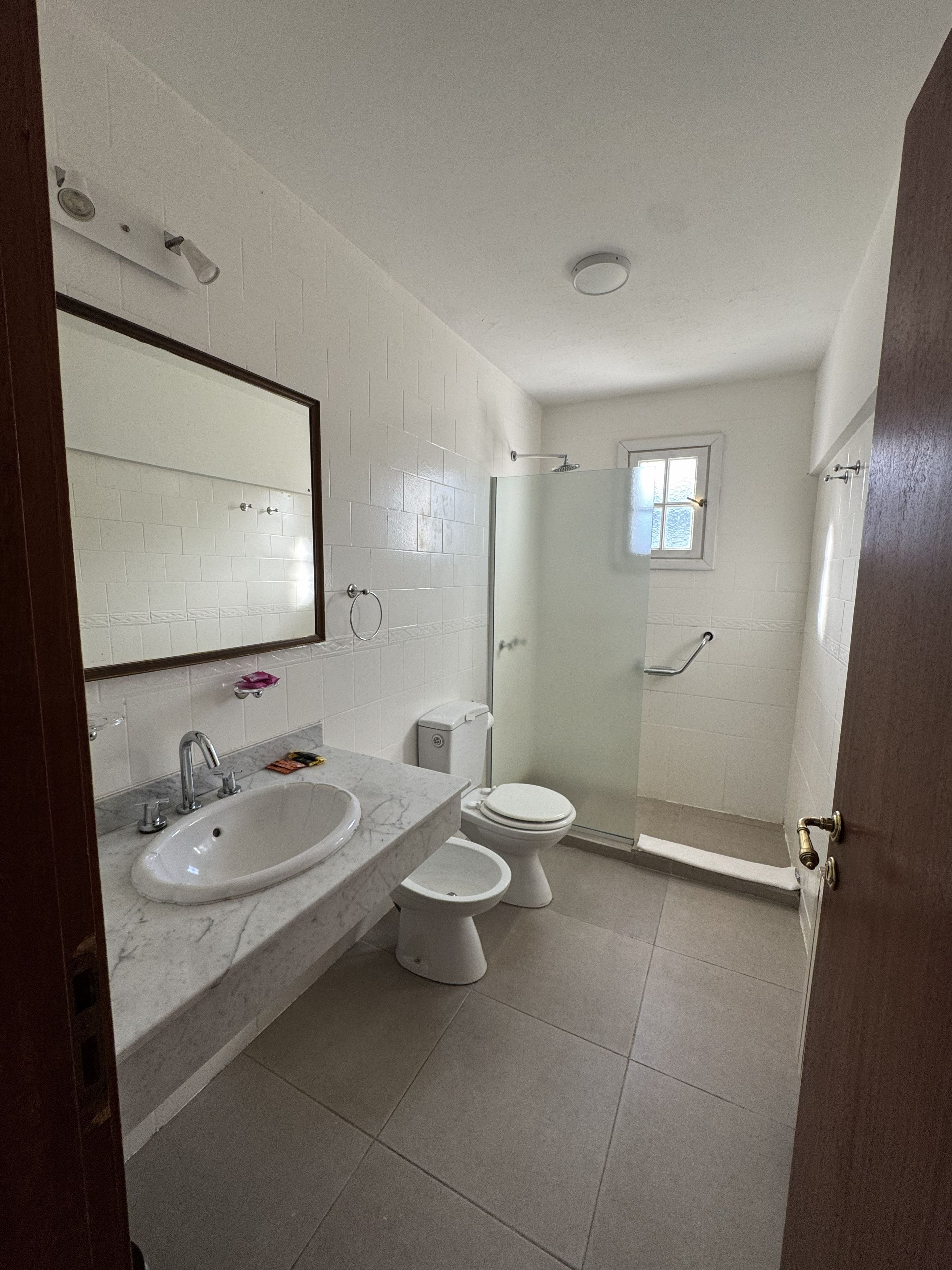 Un baño con lavamanos, inodoro y ducha.