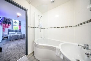 Ett modernt badrum med en duschavdelning med glasväggar, ett separat badkar och en tvättställ.